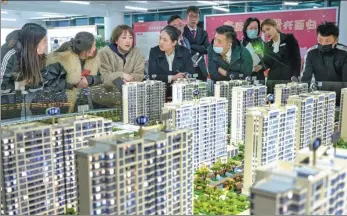  ?? WEI LIANG / CHINA NEWS SERVICE ?? Potential homebuyers look at property models in Taiyuan, Shanxi province.