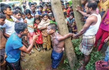  ?? AP FOTO ?? INHUMAN: Rohingya Muslims, who recently fled Myanmar to Bangladesh interrogat­e a child traffickin­g suspect in a refugee camp in Bangladesh.