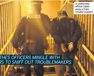  ??  ?? A uniformed officer takes away a tram trouble suspect