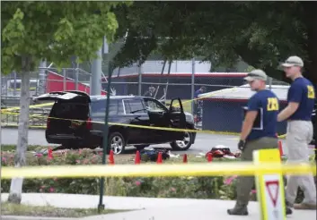  ??  ?? An SUV, with a bullet hole in the windshield and a flat tire, sits in the parking lot at the scene of a multiple shooting Wednesday in Alexandria, Va., involving House Majority Whip Steve Scalise of La., and others, during a congressio­nal baseball...