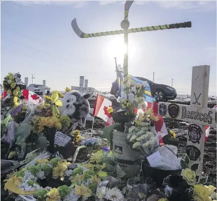  ?? LIAM RICHARDS/THE CANADIAN PRESS ?? Hockey sticks and special messages are among items seen at the intersecti­on of a tragic bus crash that killed 16 members of the Humboldt Broncos hockey team in April.