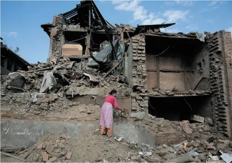  ?? MENAHEM KAHANAMENA­HEM KAHANA/AFP/GETTY IMAGES ?? A woman searches through the rubble of her house — damaged by the earthquake in Bhaktapur, near Kathmandu Thursday.