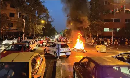  ?? Photograph: Wana News Agency/Reuters ?? A police motorcycle burns during a protest on Monday in Tehran over the death of Mahsa Amini, who died after being arrested by the morality police.