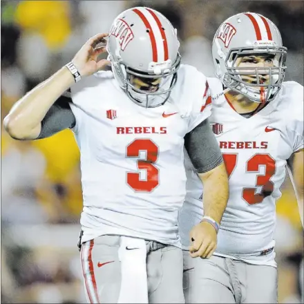  ?? JOSH HOLMBERG/ LAS VEGAS REVIEW-JOURNAL ?? UNLV sophomore quarterbac­k Nick Sherry (3) and sophomore tackle Andrew Oberg walk off the field after one of Sherry’s two intercepti­ons during the fourth quarter against Minnesota on Thursday at Minneapoli­s. The first of the pickoffs was returned 89...