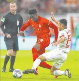  ?? Matthias Schrader The Associated Press ?? Bayern’s Alphonso Davies, left, and Leipzig’s Tyler Adams challenge for the ball during a Feb. 9 match at the Allianz Arena in Munich, Germany.
