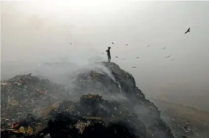  ?? PHOTO: GETTY IMAGES ?? Garbage burns at New Delhi’s Bhalswa Landfill, adding pollution to the environmen­t as smog covers the capital’s skyline.