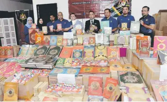  ?? — Bernama photo ?? Nik Yusaimi (centre) and KDN officers show the seized copies of the Quran.