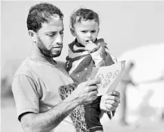  ??  ?? A Palestinia­n man reads a leaflet that was airdropped by Israeli army over Gaza. — AFP photo