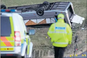  ??  ?? CRASH SCENE: Police patrol by the upturned bus near Gordon yesterday