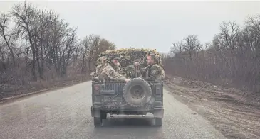  ?? AFP ?? Ukrainian servicemen drive in a military vehicle on a road near the town of Chasiv Yar, Donetsk region, amid Russia’s invasion of Ukraine. Chasiv Yar is facing a ‘difficult and tense’ situation, a Ukrainian army official said on March 25.