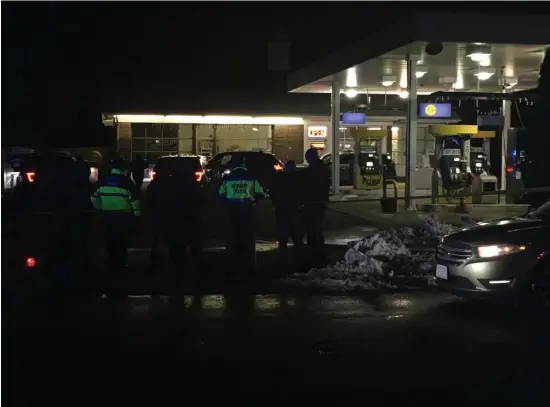  ?? COURTESY WBZ-TV ?? SHOOTING SCENE: Police gather at a gas station in the Byfield secton of Newbury where a carjacker was fatally shot on Sunday night.