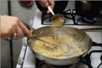  ?? RICHARD DREW — THE ASSOCIATED PRESS ?? Ruthy Kirwan, of Percolate Kitchen, wisks chicken stock into a roux as she prepares her version of the classic Thanksgivi­ng favorite Green Bean Casserole, in her apartment kitchen in the Queens borough of New York.