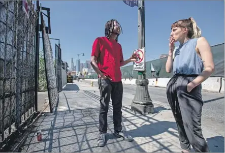  ?? Brian van der Brug Los Angeles Times ?? LOXK CALHOUN, left, and Bri Meilbeck, who came from Detroit to chase a dream in Hollywood, share a cigarette in downtown L.A.