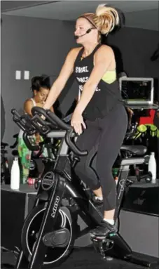  ?? MICHILEA PATTERSON — DIGITAL FIRST MEDIA ?? Summer Fatzinger, owner of the fitness studio TORQUE in Upper Providence, leads an indoor cycling class called spin. The class was done in a darkened room with energetic music playing in the background.