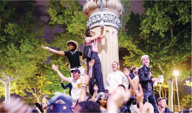  ?? Reuters ?? ↑
People gather in a drinking and dancing session on a street as the state of emergency, decreed by the Spanish govt, is lifted in Barcelona on Monday.