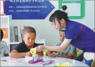  ??  ?? Peng Jing shows her students a Mobius Strip in Minning town.