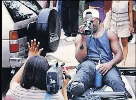  ?? AJC FILE PHOTO ?? Freaknik attendees use ancient contraptio­ns known as video cameras during the rolling party’s mid-1990s heyday. A supposed comeback appears to be just another party with a clever marketing campaign.