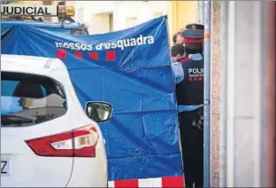  ?? LLIBERT TEIXIDÓ ?? Los mossos custodian la puerta del domicilio en la calle Joan Maragall