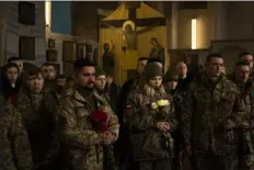  ?? VADIM GHIRDA — THE ASSOCIATED PRESS ?? Ukrainian soldiers attend the funeral of Hennadii Kovshyk, who was killed on the frontline in eastern Ukraine, in Kharkiv, Ukraine, on Thursday.