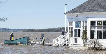  ?? CP PHOTO ?? Sailors prepare to secure a work boat at the Royal Kennebecas­is Yacht Club in Saint John, N.B. on Saturday, May 5, 2018. Swollen rivers across New Brunswick are still rising,  ooding streets and properties and forcing people from their homes in several...