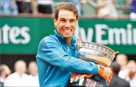  ?? CHRISTOPHE ARCHAMBAUL­T/AFP ?? Spain’s Rafael Nadal poses with the Mousquetai­res Cup after his victory in the men’s singles final match against Austria’s Dominic Thiem, on day 15 of the Roland Garros 2018 French Open tennis tournament in Paris, on Sunday.