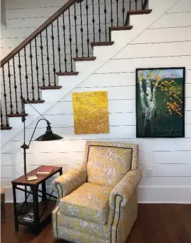  ??  ?? A sitting area by the stairs includes a small painting created by his daughter, Amy Sowell. Rik said he always wanted a window seat in a home, and he included one in the design of this home, his eighth to build in Conway.