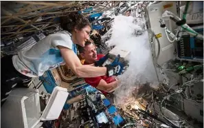  ??  ?? Nasa astronauts Christina Koch and Andrew Morgan stow biological research samples into a science freezer located inside the
US Destiny laboratory module. — NASA/TNS