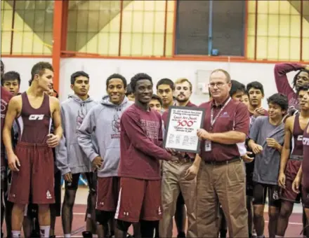  ?? NATE HECKENBERG­ER — DIGITAL FIRST MEDIA ?? Church Farm coach Art Smith accepts a certificat­e from Senior Gyamfi along with his team after winning his 300th career dual meet as a coach following Wednesday’s victory over Bristol.