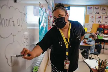  ?? Billy Calzada / Staff photograph­er ?? Vanessa Garza, an interventi­on teacher at Copperfiel­d Elementary School in Judson ISD, works with students. More than 3,300 district employees received $50 H-E-B gift cards as thanks for their work and adaptabili­ty during the pandemic.