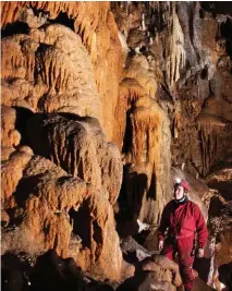  ??  ?? Deborah is dwarfed by Mammoth Cave’s crystal formations, deposited by mineral-rich rainwater that has seeped deep undergroun­d over hundreds of thousands of years.