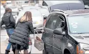  ?? MATT STONE / BOSTON HERALD ?? A passenger gets into a rideshare car at South Station in 2019. After an alleged kidnapping attempt by a driver, a trade group is calling for rideshare drivers to undergo fingerprin­t checks.