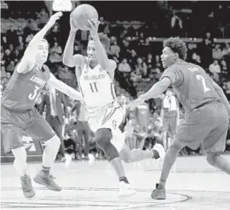  ?? ABBIE PARR/GETTY IMAGES ?? Braian Angola of the Florida State Seminoles, works toward the basket against Ryan McMahon (30) and Darius Perry, (2) of Louisville on Wednesday.