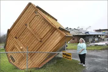  ?? Rick Barbero/The Register-Herald via AP ?? Jamie Coleman on Wednesday looks at her storage building, which blew over in her yard along Route 60 in Hico, W.Va., during a storm that hit the area the day before.