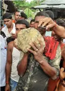 ??  ?? A villager holds the suspected meteorite. Photograph: STR/AFP/Getty Images