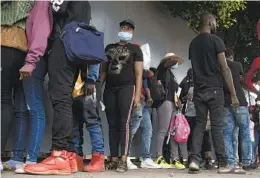  ?? GUILLERMO ARIAS AFP VIA GETTY IMAGES ?? Haitian migrants queue to register with the National Commission for Refugees in Tijuana on Wednesday. Many say they were originally heading to the U.S.