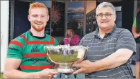  ??  ?? Oban Lorne RFC president Sandy Rokitta hands over the Tower 10s trophy to club captain Craig Wright.