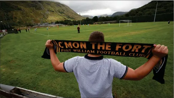  ??  ?? A Fort William supporter cheers on the Highland League outfit in the shadow of Ben Nevis – his club have not won a game since April 2017