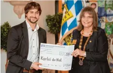  ?? Foto: Frank Riederle ?? MN Redakteur Stefan Reinbold nahm 500 Euro aus den Händen der Präsidenti­n des Rotary Club Schwäbisch­er Barockwink­el, Claudia Prommersbe­rger Fischer, für die Kartei der Not entgegen.