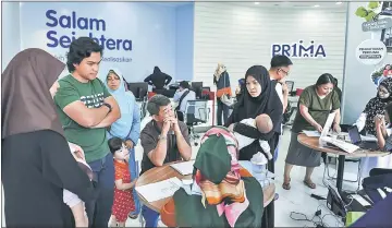  ??  ?? Family of Mohd Nissfus and Sarafina Zainal Abidin (left) waiting to apply for their home at the open house. — Bernama photo