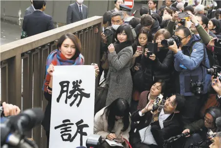  ?? Takashi Aoyama / Getty Images ?? Journalist Shiori Ito holds a sign declaring victory in front of a Tokyo courthouse. She called the ruling a milestone in Japan.