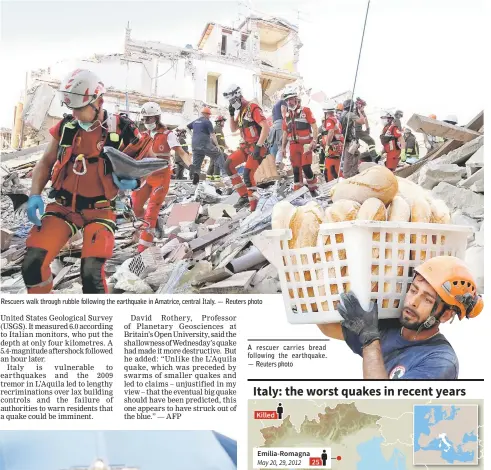  ??  ?? Rescuers walk through rubble following the earthquake in Amatrice, central Italy. — Reuters photo A rescuer carries bread following the earthquake. — Reuters photo