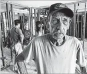  ?? ROBIN MCDOWELL/AP ?? Bob Janak, 71, of Magnolia, surveys his flood-damaged home Monday. Volunteers cleared out soggy debris.