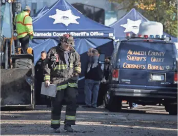  ?? ELIJAH NOUVELAGE/ GETTY IMAGES ?? A firefighte­r walks at the site of a warehouse fire that killed at least 30 at an electronic-music party Friday night.