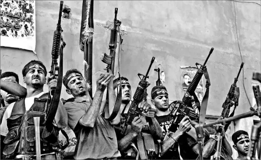  ?? JAAFAR ASHTIYEH/ AFP/ GETTY IMAGES ?? Palestinia­n militants from the Al Aqsa Martyrs Brigades brandish their weapons during a rally yesterday in Balata refugee camp, near the West Bank town of Nablus.