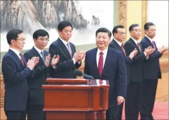  ?? WU ZHIYI / CHINA DAILY ?? Other members of the new Standing Committee of the Political Bureau of the CPC Central Committee applaud General Secretary Xi Jinping as he prepares to address reporters at the Great Hall of the People in Beijing on Wednesday.