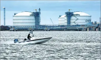  ?? BLOOMBERG VIA GETTY IMAGES ?? A powerboat passes storage tanks at the Cheniere Energy Inc liquefied natural gas terminal in Sabine Pass, Louisiana.