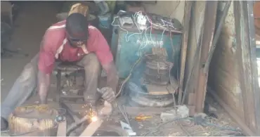  ??  ?? A welder at work using power from a generator in Kafanchan.