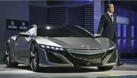  ?? DAVID COOPER/TORONTO STAR ?? Takanobu Ito, president and CEO of Honda Motor Co., stands with the Acura NSX concept that will be on display at the Toronto auto show.