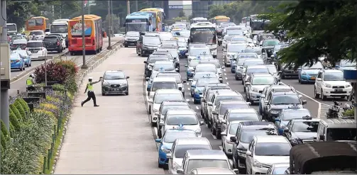  ?? HARITSAH ALMUDATSIR/JAWA POS ?? UJI COBA: Polisi menghentik­an seorang pengendara mobil karena menerobos jalur busway. Arus macet terjadi di Sudirman saat penghapusa­n kawasan 3 in 1 kemarin.