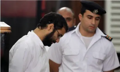  ?? Photograph: Al Youm Al Saabi/ Reuters ?? Activist Alaa Abd el-Fattah stands in front of a police officer at a court during his trial in Cairo in 2014.